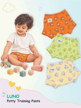 Baby in orange LUNO potty training pants next to avocado, cartoon, and pale yellow patterned pairs.