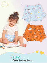 Toddler drawing in unicorn LUNO potty training pants next to alternative rainbow and Puppy prints.