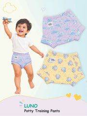 Smiling toddler in Paper Plane print LUNO potty training pants next to lavender and yellow pairs