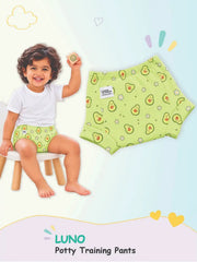 Child in avocado flower LUNO potty training pants on a stool next to a matching flat-lay pair.